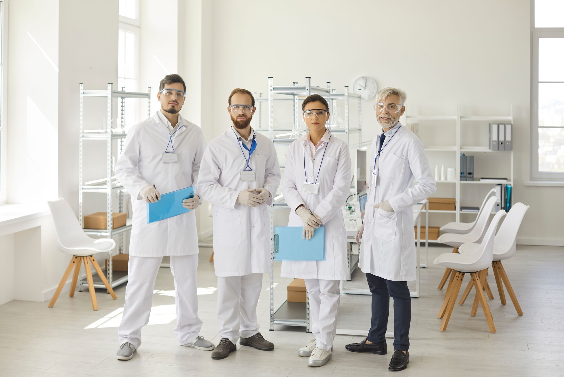 Diverse scientist group standing at laboratory looking at camera portrait